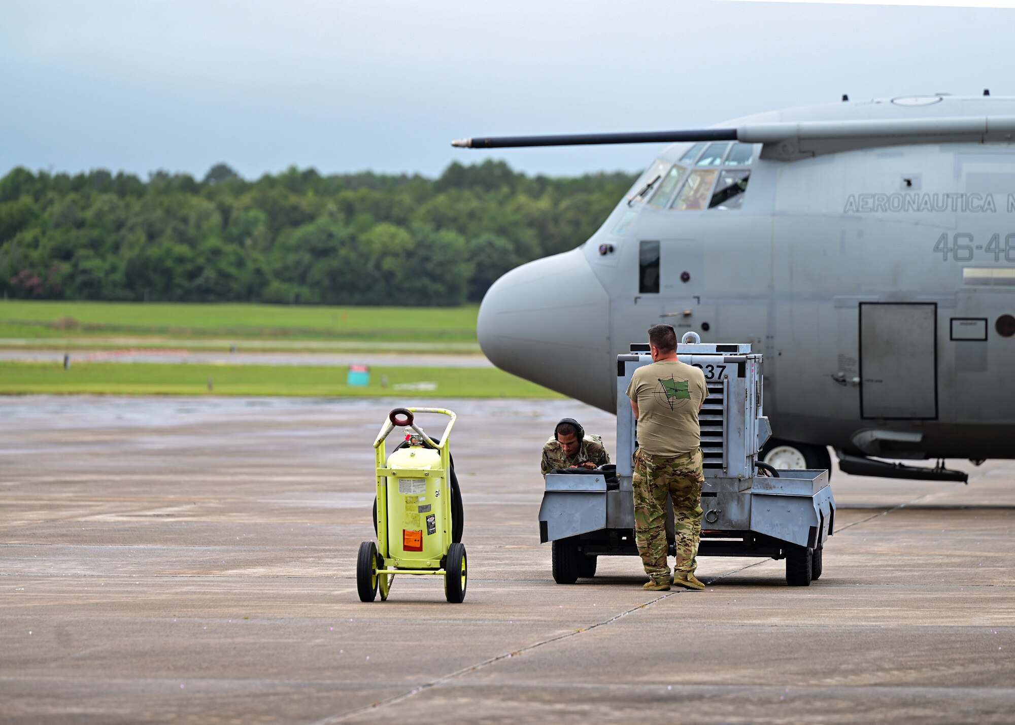 Two Airmen assigned to the 19th Airlift Wing move a power cart