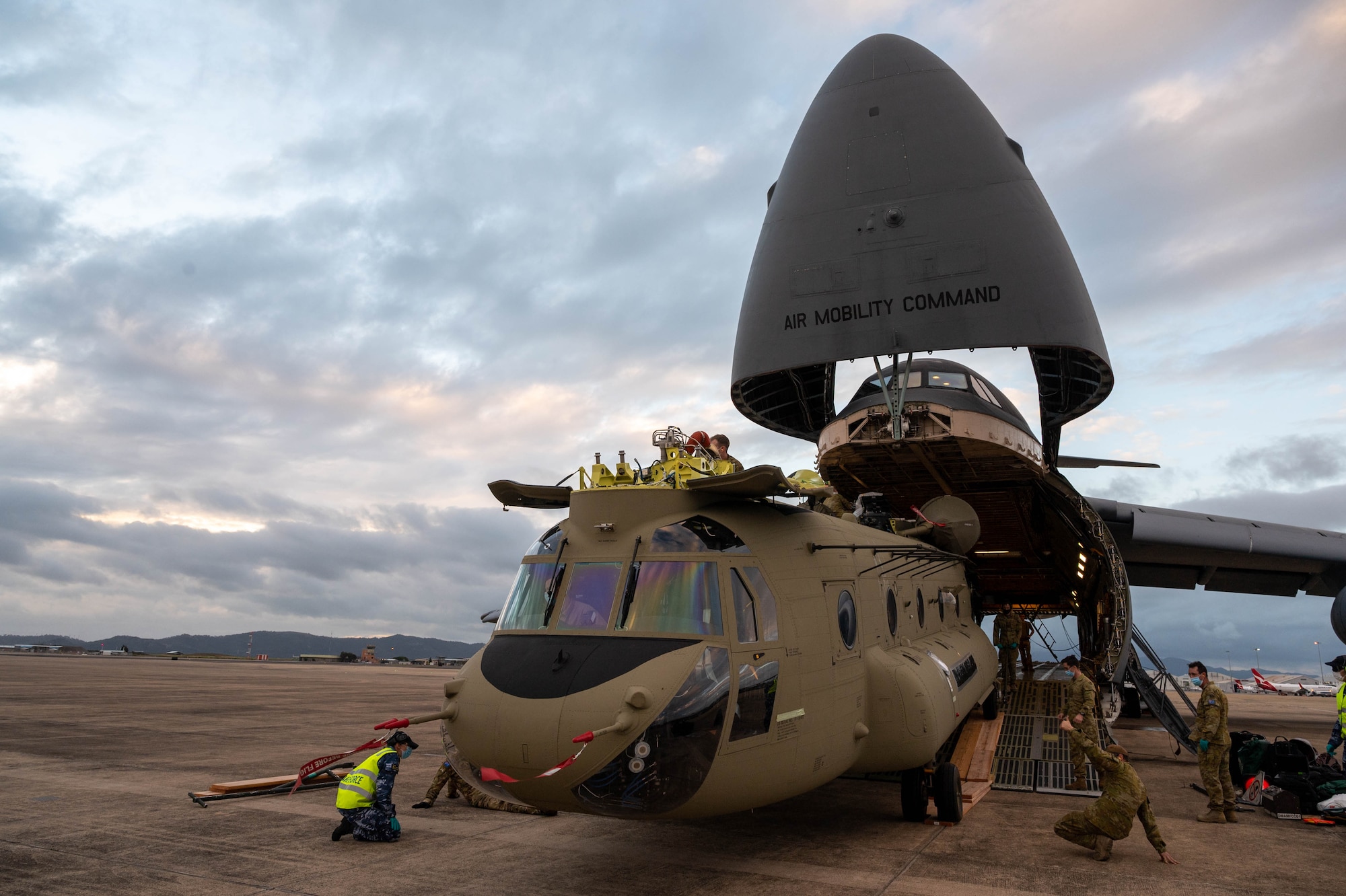 A CH-47F Chinook helicopter is unloaded from a Dover Air Force Base C-5M Super Galaxy at Royal Australian Air Force Base Townsville, Australia, July 7, 2021. The C-5 transported two CH-47F Chinook helicopters to RAAF Base Townsville as a part of the Department of Defense’s Foreign Military Sales program. The U.S. and Australia maintain a robust relationship underpinned by shared democratic values, common interests and cultural bonds. The strong alliance is an anchor for peace and stability in the Indo-Pacific region and around the world. (U.S. Air Force photo by Senior Airman Faith Schaefer)