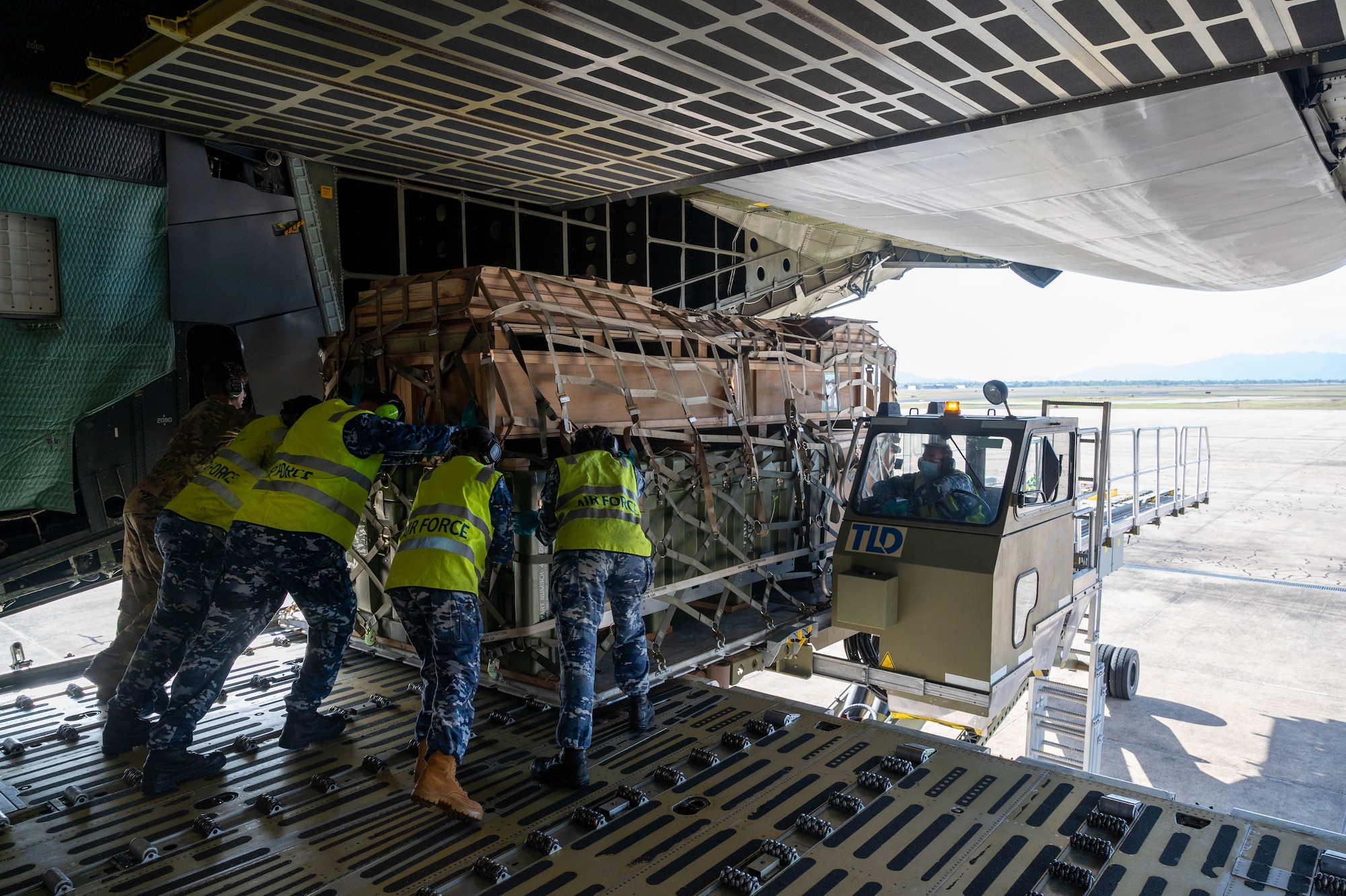 Airmen from the Royal Australian Air Force, along with 9th Airlift Squadron loadmasters, push a cargo pallet onto a K-loader from the ramp of a Dover Air Force Base C-5M Super Galaxy at RAAF Base Townsville, Australia, July 7, 2021. The C-5 transported two CH-47F Chinook helicopters to RAAF Base Townsville as a part of the Department of Defense’s Foreign Military Sales program. The U.S. and Australia maintain a robust relationship underpinned by shared democratic values, common interests and cultural bonds. The strong alliance is an anchor for peace and stability in the Indo-Pacific region and around the world. (U.S. Air Force photo by Senior Airman Faith Schaefer)