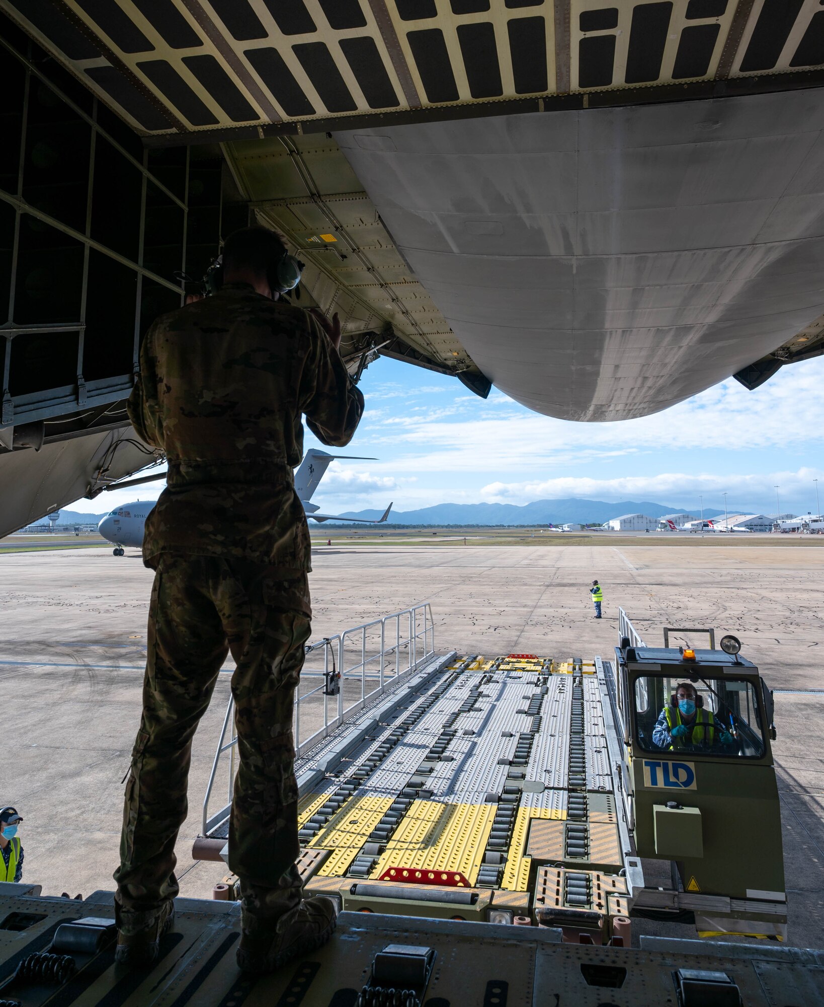 U.S. Air Force Staff Sgt. John Dittess, 9th Airlift Squadron loadmaster, marshals a K-loader to the ramp of a Dover Air Force Base C-5M Super Galaxy at Royal Australian Air Force Base Townsville, Australia, July 7, 2021. The C-5 transported two CH-47F Chinook helicopters to RAAF Base Townsville as a part of the Department of Defense’s Foreign Military Sales program. The U.S. and Australia maintain a robust relationship underpinned by shared democratic values, common interests and cultural bonds. The strong alliance is an anchor for peace and stability in the Indo-Pacific region and around the world. (U.S. Air Force photo by Senior Airman Faith Schaefer)