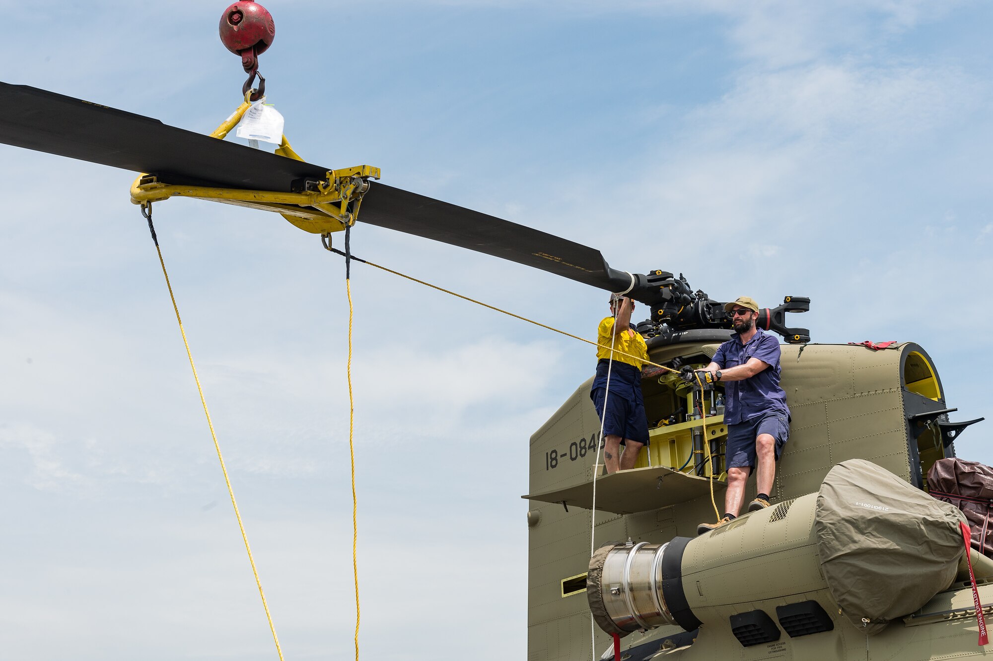 Boeing Defence Australia maintenance team members remove a rotor blade from a CH-47F Chinook helicopter at Dover Air Force Base, Delaware, June 9, 2021. BDA maintenance personnel readied two Chinooks for shipment aboard a C-5M Super Galaxy as part of the U.S. government’s foreign military sales program. The U.S.-Australia alliance is an anchor for peace and stability in the Indo-Pacific region and around the world. (U.S. Air Force photo by Roland Balik)