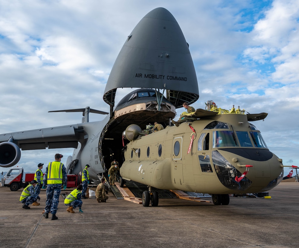 A CH-47F Chinook helicopter is unloaded from a Dover Air Force Base C-5M Super Galaxy at Royal Australian Air Force Base Townsville, Australia, July 7, 2021. The C-5 transported two CH-47F Chinook helicopters to RAAF Base Townsville as a part of the Department of Defense’s Foreign Military Sales program.