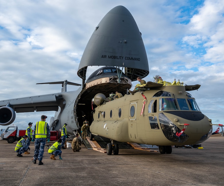 A CH-47F Chinook helicopter is unloaded from a Dover Air Force Base C-5M Super Galaxy at Royal Australian Air Force Base Townsville, Australia, July 7, 2021. The C-5 transported two CH-47F Chinook helicopters to RAAF Base Townsville as a part of the Department of Defense's Foreign Military Sales program.