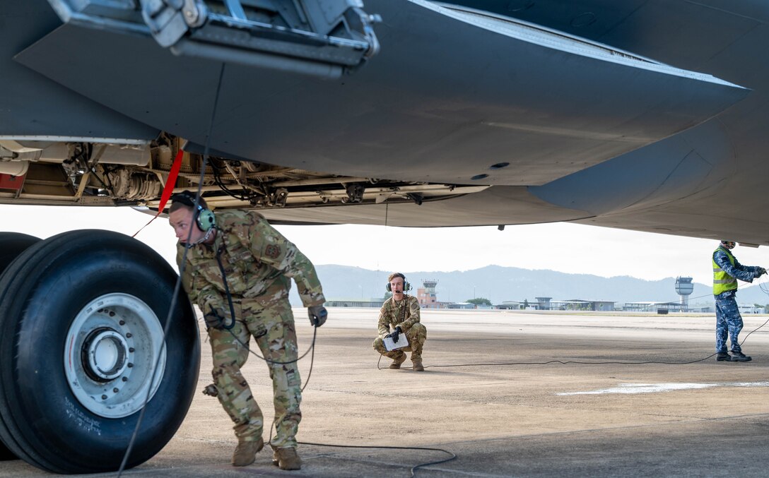 U.S. Air Force Staff Sgt. Larry White, left, 9th Airlift Squadron flight engineer, performs a tire check on a Dover Air Force Base C-5M Super Galaxy at Royal Australian Air Force Base Townsville, Australia, July 7, 2021. The C-5 transported two CH-47F Chinook helicopters to RAAF Base Townsville as a part of the Department of Defense’s Foreign Military Sales program. The U.S. and Australia maintain a robust relationship underpinned by shared democratic values, common interests and cultural bonds. The strong alliance is an anchor for peace and stability in the Indo-Pacific region and around the world. (U.S. Air Force photo by Senior Airman Faith Schaefer)