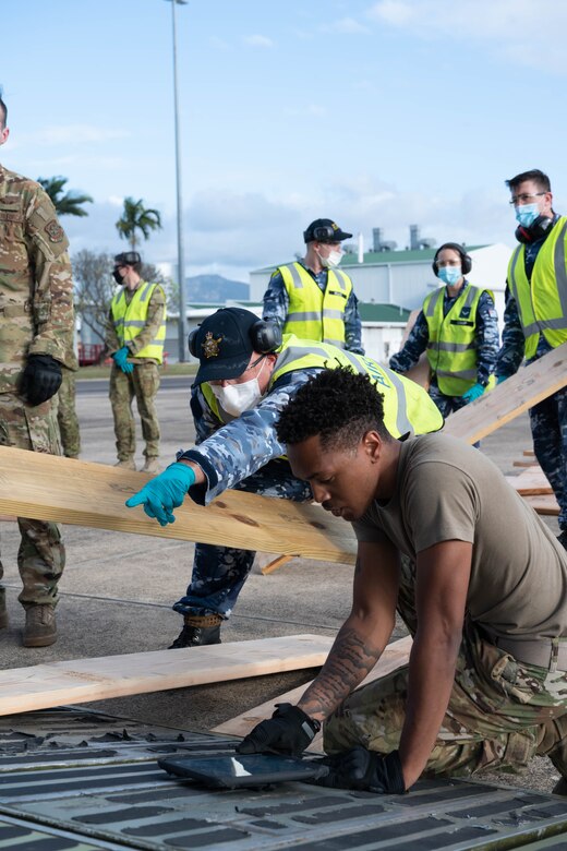 U.S. Air Force Staff Sgt. Gregory McBride, right, 9th Airlift Squadron loadmaster, checks ramp shoring procedures on a Dover Air Force Base C-5M Super Galaxy cargo ramp at Royal Australian Air Force Base Townsville, Australia, July 7, 2021. The C-5 transported two CH-47F Chinook helicopters to RAAF Base Townsville as a part of the Department of Defense’s Foreign Military Sales program. The U.S. and Australia maintain a robust relationship underpinned by shared democratic values, common interests and cultural bonds. The strong alliance is an anchor for peace and stability in the Indo-Pacific region and around the world. (U.S. Air Force photo by Senior Airman Faith Schaefer)