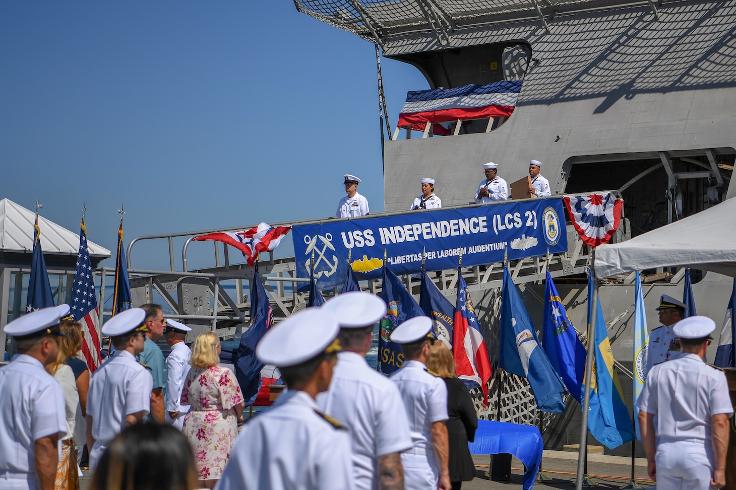 Ship's crew deliver the ensign and commissioning pennant during the decommissioning ceremony of littoral combat ship USS Independence (LCS 2).