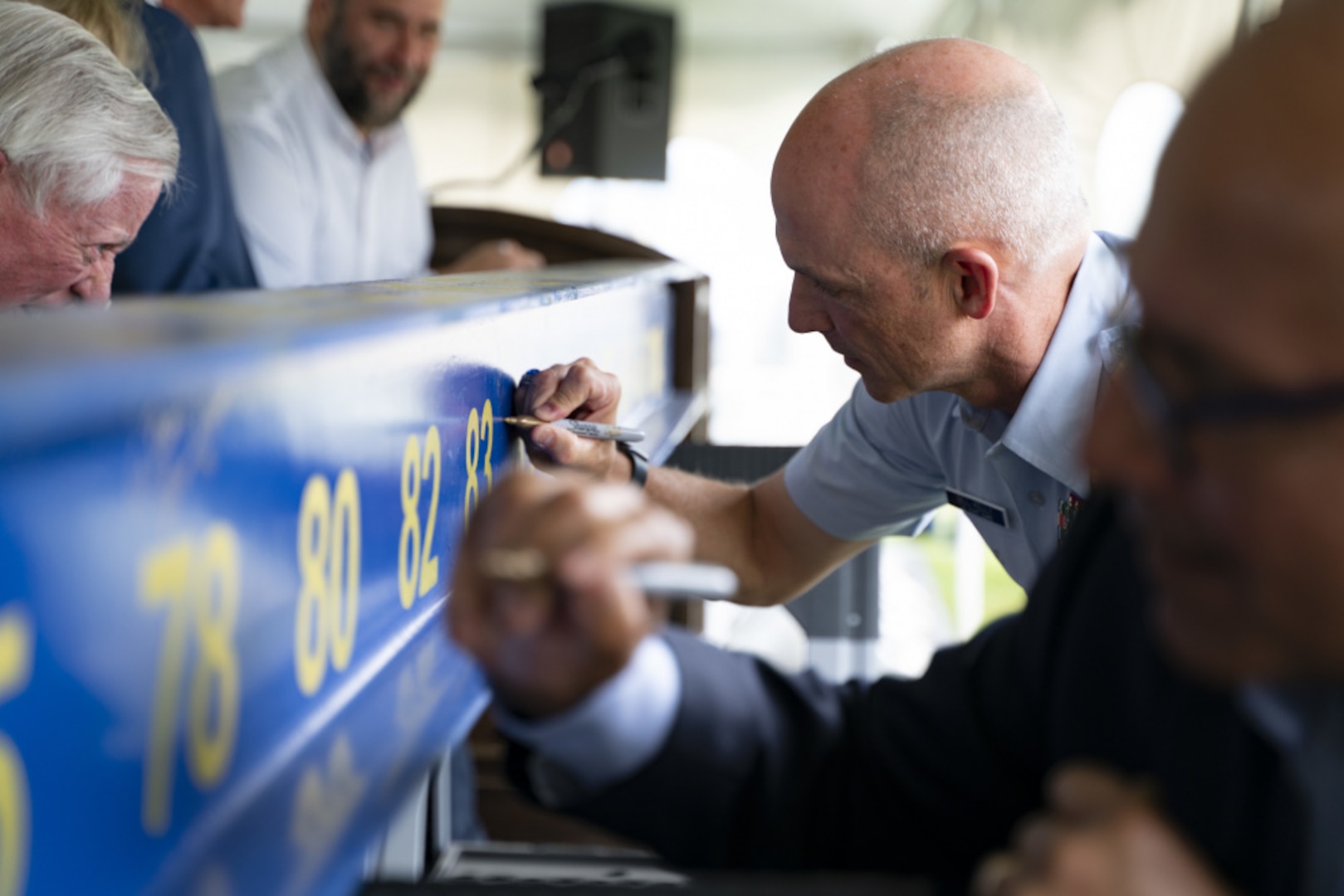 In a twist on the traditional groundbreaking ceremony, U.S. Coast Guard leaders signed a ceremonial steel beam which will be used in the construction of the future Maritime Center of Excellence (MCOE) at the U.S. Coast Guard Academy, July 29, 2021. The future MCOE will enhance the waterfront facilities at the Academy by offering interactive and high-tech classrooms for a variety of educational and leadership development courses. (U.S. Coast Guard photo by Petty Officer 3rd Class Matthew Thieme)