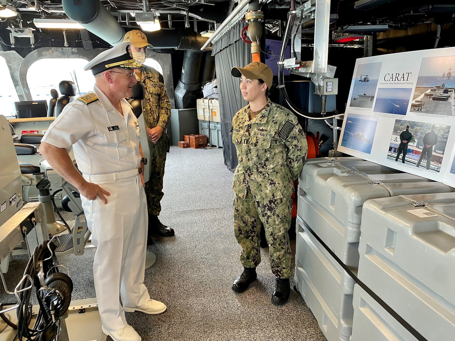 CNO Gilday speaks to a Sailor in front of a display.