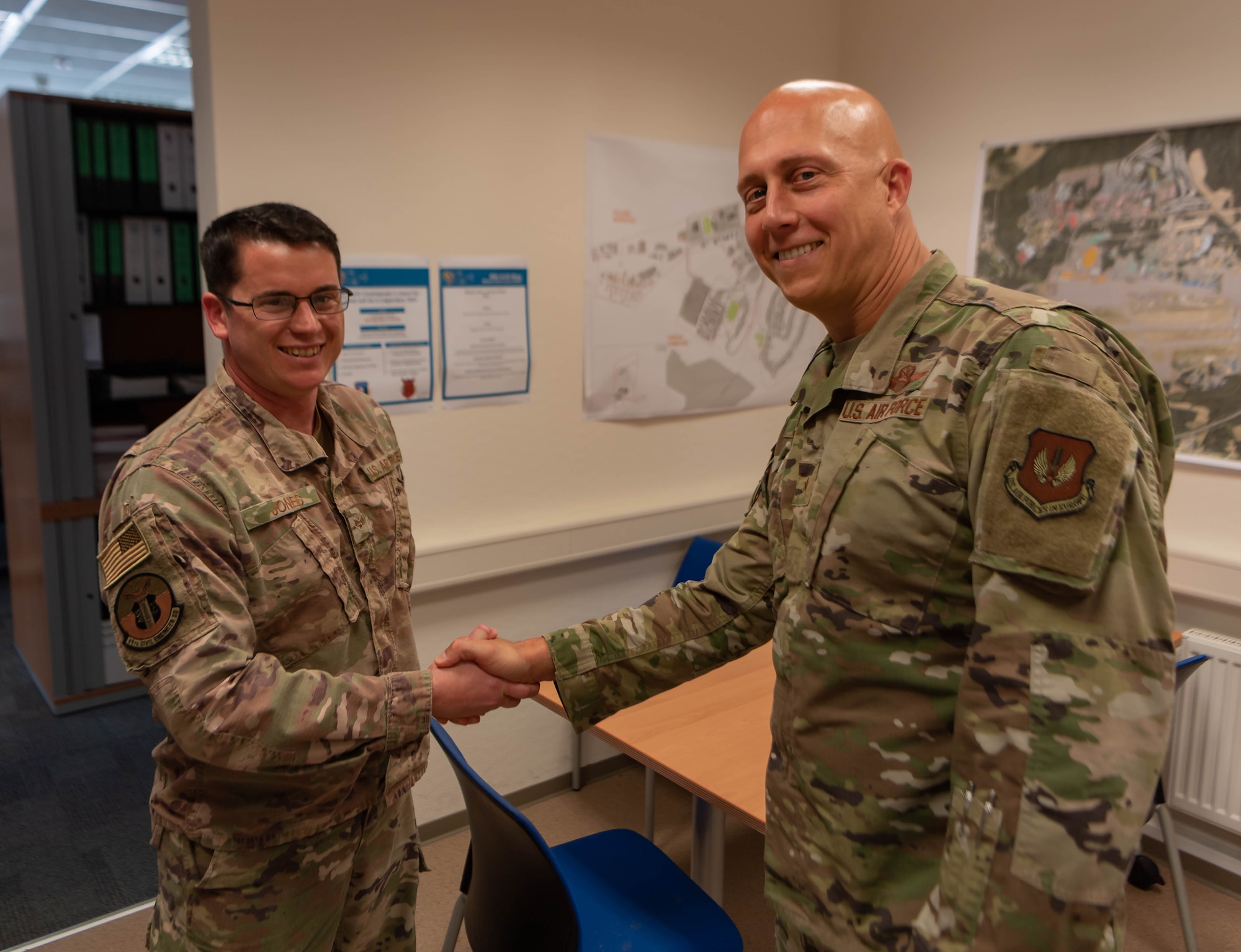 U.S. Air Force Senior Airman James Jones, a controlled movement area escort and project manager assigned to the 86th Civil Engineering Squadron, shakes hands with USAF Brig. Gen. Joshua Olson, 86th Airlift Wing commander at Ramstein Air Base, Germany, July 22, 2021. Jones was recognized as Airlifter of the Week for his ability to improve processes at Ramstein such as the escort augmentee program.
(U.S. Air Force photo by Airman Jared Lovett)