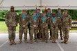 three soldiers posing for a photo in front of flags.