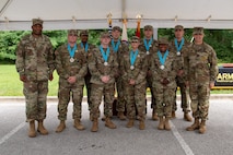 three soldiers posing for a photo in front of flags.