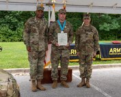 three soldiers posing for a photo in front of flags.