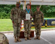 three soldiers posing for a photo in front of flags.