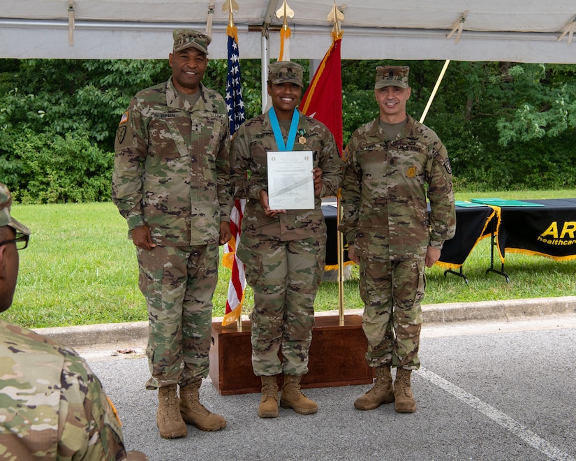 three soldiers posing for a photo in front of flags.