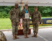 three soldiers posing for a photo in front of flags.