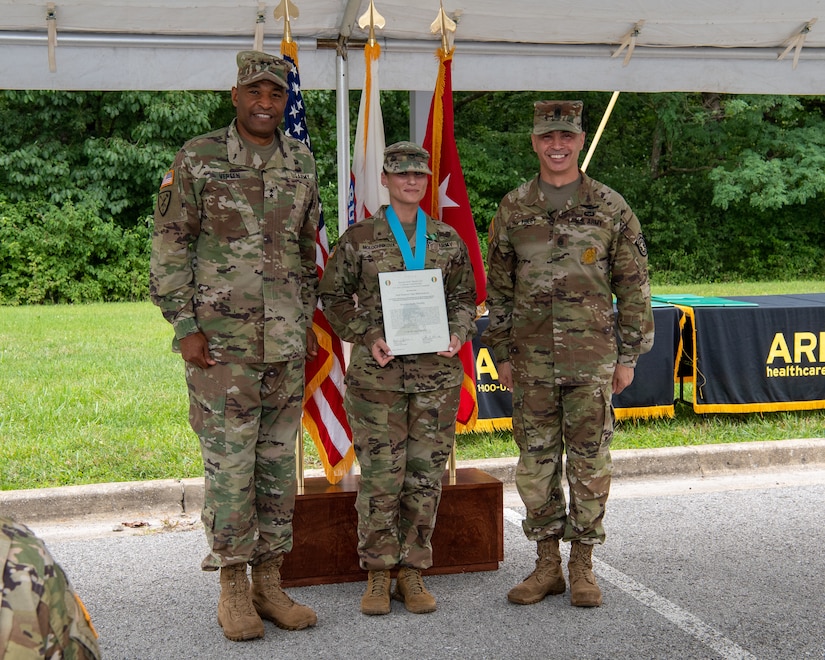 three soldiers posing for a photo in front of flags.