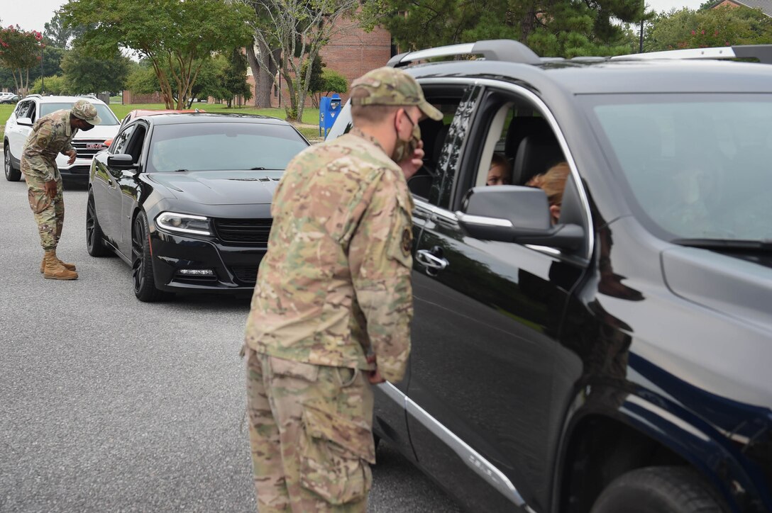 U.S. Air Force Airmen with the Airmen and Family Readiness Center and volunteers greet service members in their vehicles during an event supporting Operation Homefront at Moody Air Force Base, Georgia, July 26, 2021. Volunteers and event coordinators handed out 192 bags of school supplies to Airmen, E-6 and below. (U.S. Air Force photo by Senior Airman Rebeckah Medeiros)
