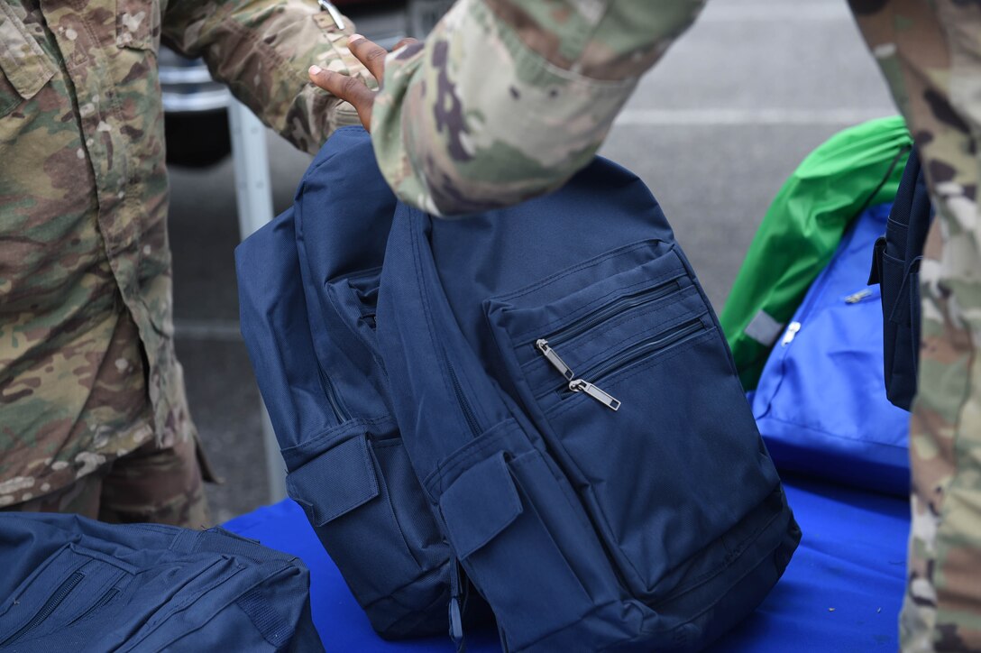 U.S. Air Force Airmen distribute backpacks with school supplies to service members during an event supporting Operation Homefront at Moody Air Force Base, Georgia, July 26, 2021. Operation Homefront is a non-profit organization whose mission is “to build strong, stable, and secure military families so they can thrive in the communities they have worked so hard to protect.” (U.S. Air Force photo by Senior Airman Rebeckah Medeiros)