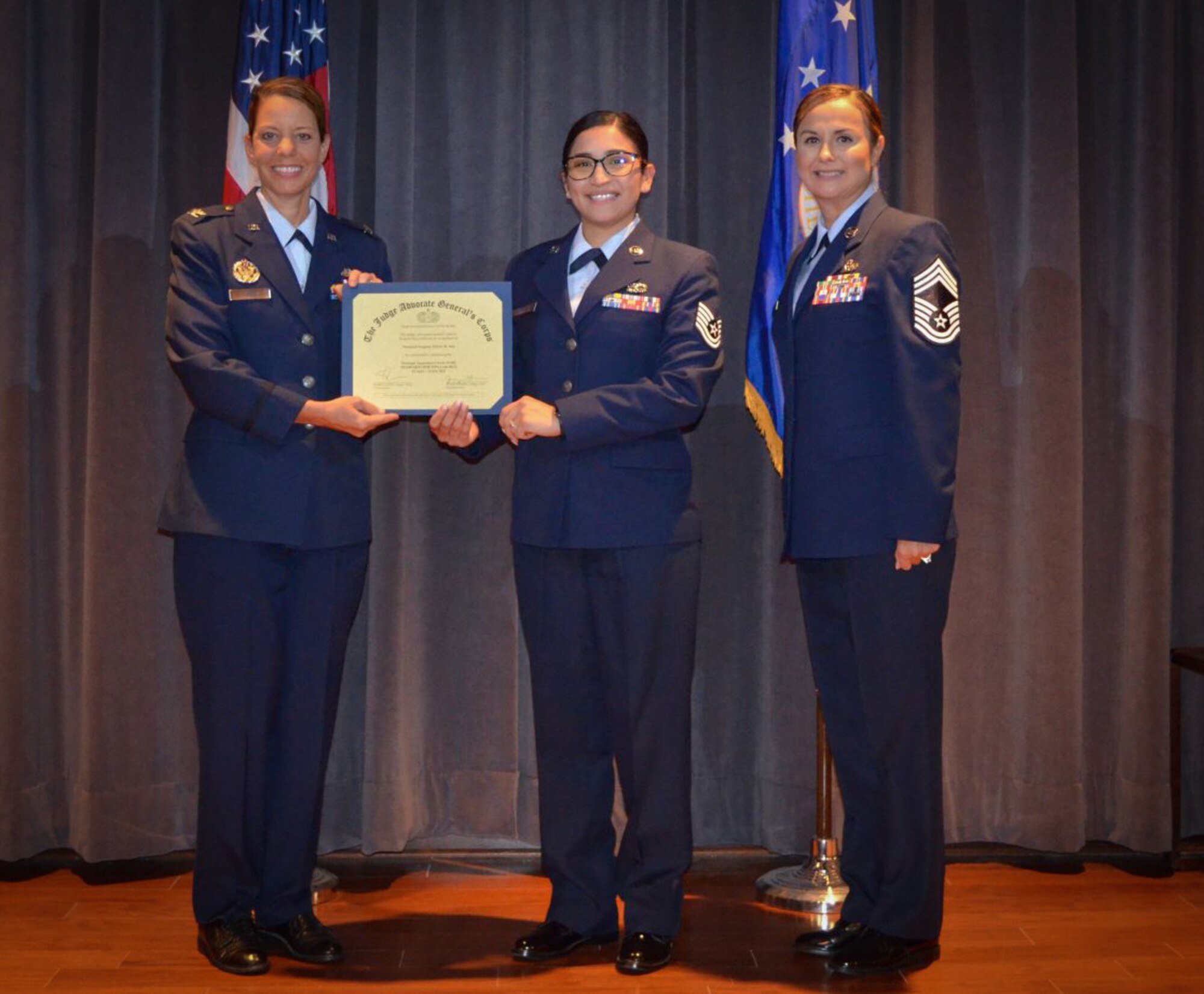(center) 301st Fighter Wing's Tech. Sgt. Felicia Ash receives her Paralegal Apprentice Course (PAC) certification during a graduation ceremony at The Judge Advocate General’s School, Maxwell Air Force Base, Ala., July 2021. Ash was recognized as the course's distinguished graduate for her superior performance. (courtesy photo)