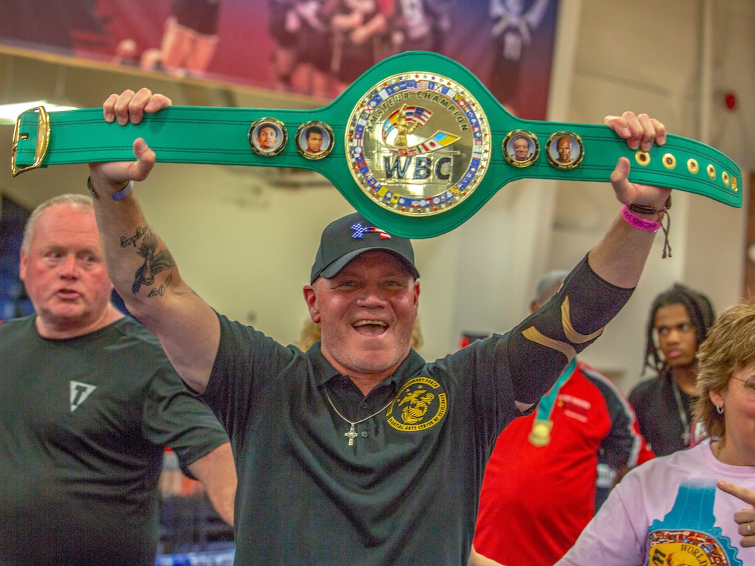 Joe Higgins, head coach of the II Marine Expeditionary Force, Martial Arts Center of Excellence, raises the Team Belt at the Christy Martin’s Title Boxing Invitational, Fayetteville, N.C., July 25, 2021. The Christy Martin’s Title Boxing Invitational, named after the 2019 International Hall of Famer, attracted elite fighters from across the eastern Carolinas. The II MEF MACE achieved five weight-class championships and won the overall Team Belt. (U.S. Marine Corps photo by Lance Cpl. Eric Ramirez)