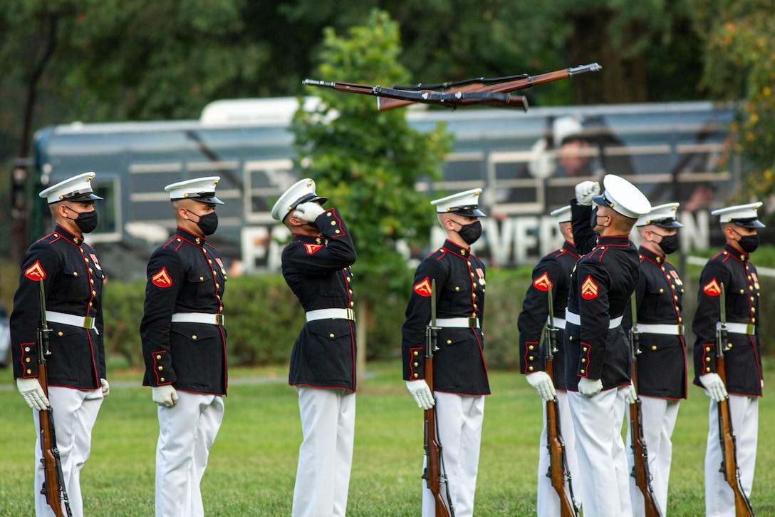 Marines with the Silent Drill Platoon execute their “rifle inspection” sequence during the Non-Commissioned Officer Tuesday Sunset Parade at the Marine Corps War Memorial, Arlington, Va., July 27, 2021. The hosting official for the evening was Sgt. Maj. Troy E. Black, Sergeant Major of the Marine Corps, and the guest of honor was Ms. Melissa Cohen, Director, Department of the Navy Sexual Assault Prevention and Response Office.  (U.S. Marine Corps photo by Lance Cpl. Tanner Lambert)