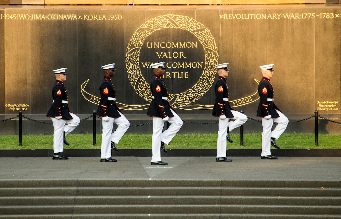 Marines with the parade staff march into position during the Non-Commissioned Officer Tuesday Sunset Parade at the Marine Corps War Memorial, Arlington, Va., July 27, 2021.