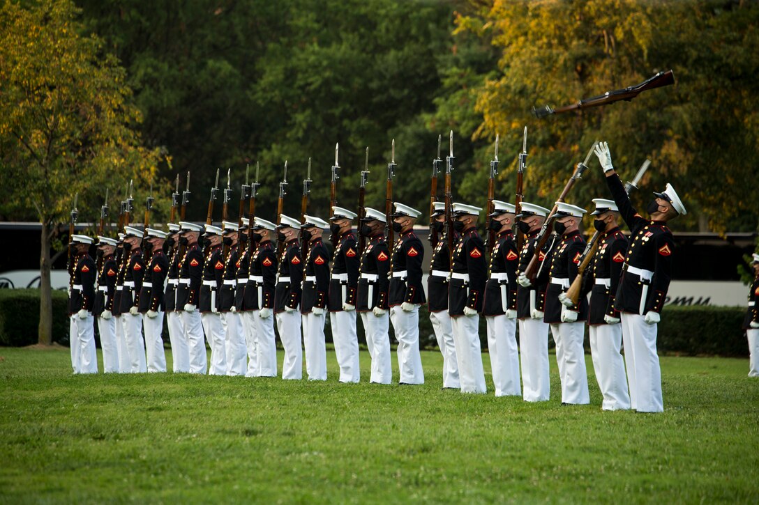 Marines with the Silent Drill Platoon execute their “long line” sequence during the Non-Commissioned Officer Tuesday Sunset Parade at the Marine Corps War Memorial, Arlington, Va., July 27, 2021. The hosting official for the evening was Sgt. Maj. Troy E. Black, Sergeant Major of the Marine Corps, and the guest of honor was Ms. Melissa Cohen, Director, Department of the Navy Sexual Assault Prevention and Response Office. (U.S. Marine Corps photo by Lance Cpl. Allen Sanders)