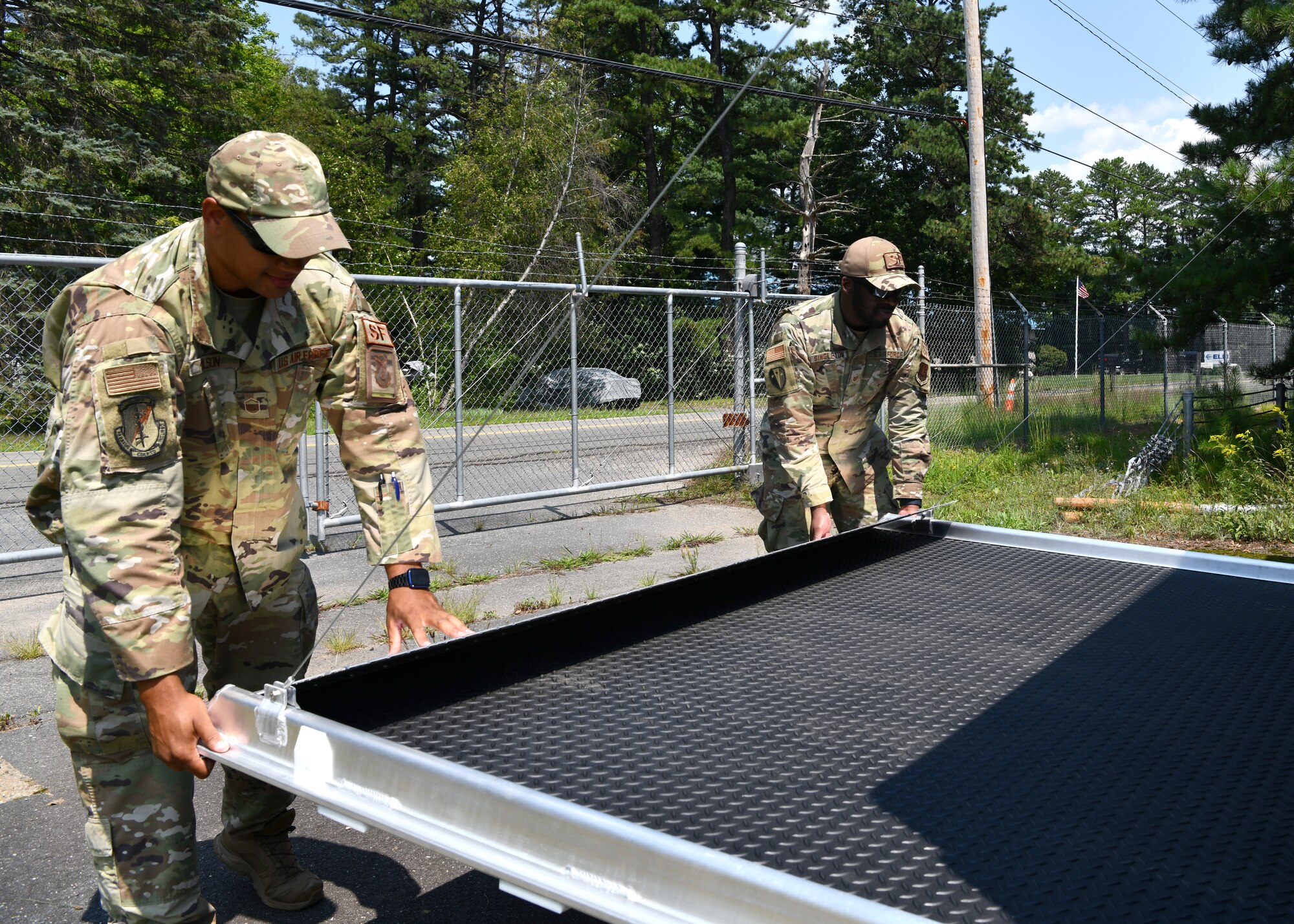Master Sgt. Wayne Wilson and Master Sgt. Sandy Singleton, 104th Security Forces Squadron members close the back of a domestic operations trailer on July 27, 2021 at Barnes Air National Guard Base. The trailers are compact enough to fit inside C-130, C-17 and C-5 aircraft and quickly deployable to all locations worldwide via air or land. (U.S. Air National Guard Photo by Senior Airman Camille Lienau)