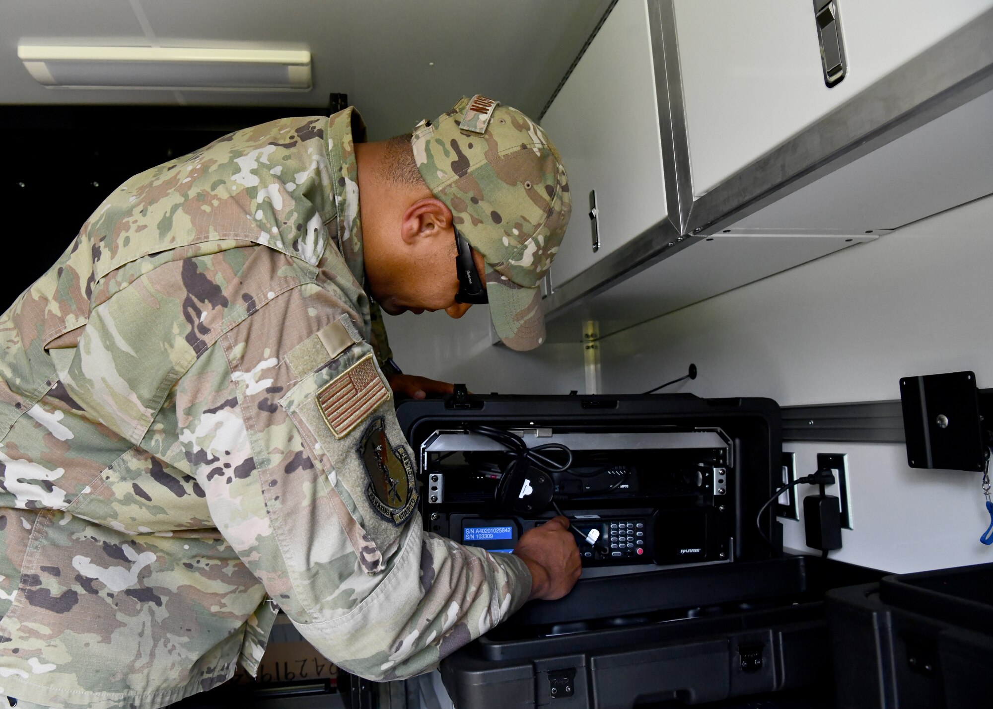 Master Sgt. Wayne Wilson, 104th Security Forces Squadron member adjusts the radio inside of a domestic operations trailer on July 27, 2021 at Barnes Air National Guard Base. The built-in radio system allows for communication between SFS members and civilian law enforcement agencies. (U.S. Air National Guard Photo by Senior Airman Camille Lienau)