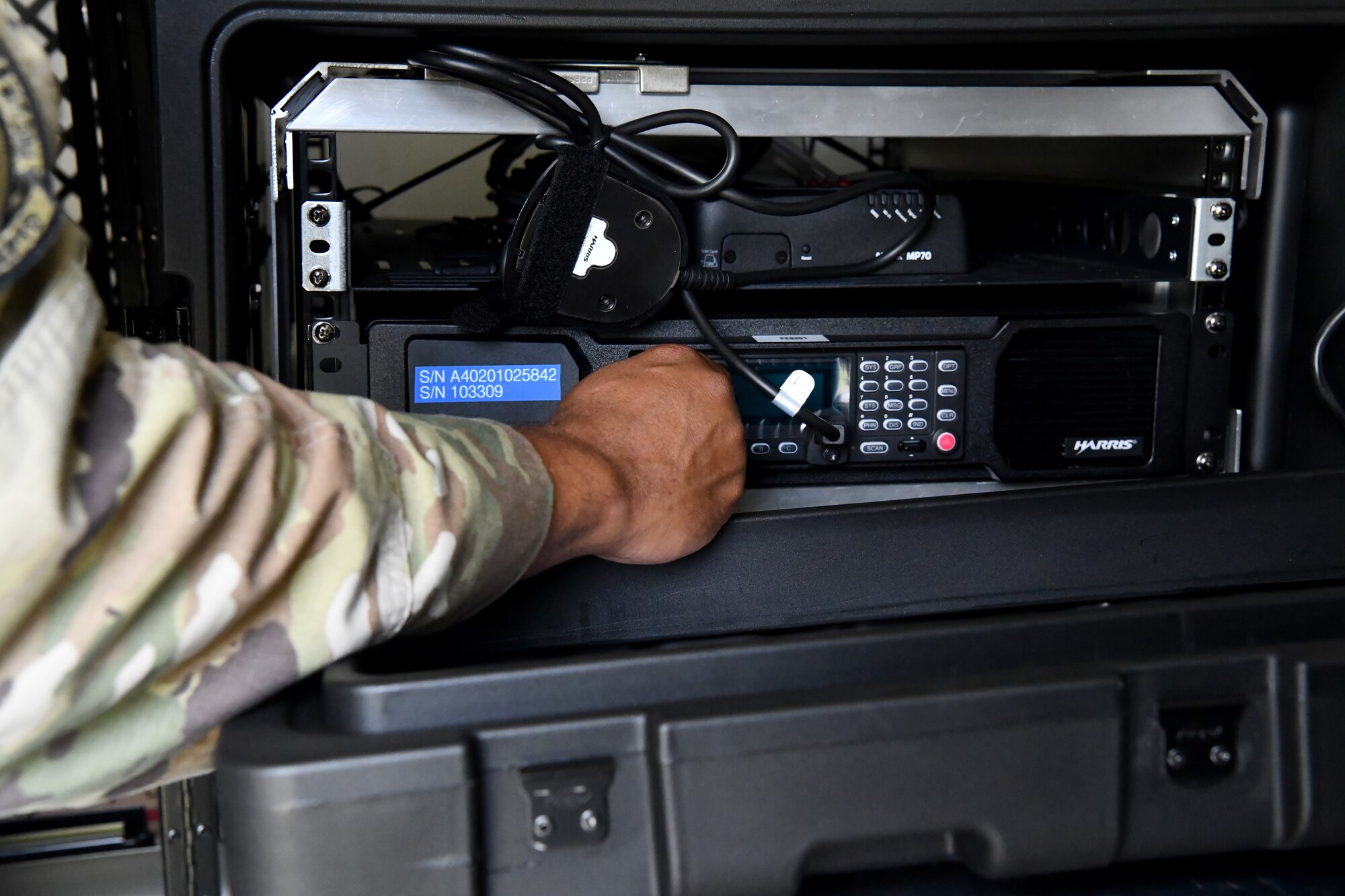 Master Sgt. Wayne Wilson, 104th Security Forces Squadron member adjusts the radio inside of a domestic operations trailer on July 27, 2021 at Barnes Air National Guard Base. The built-in radio system allows for communication between SFS members and with civilian law enforcement agencies. (U.S. Air National Guard Photo by Senior Airman Camille Lienau)