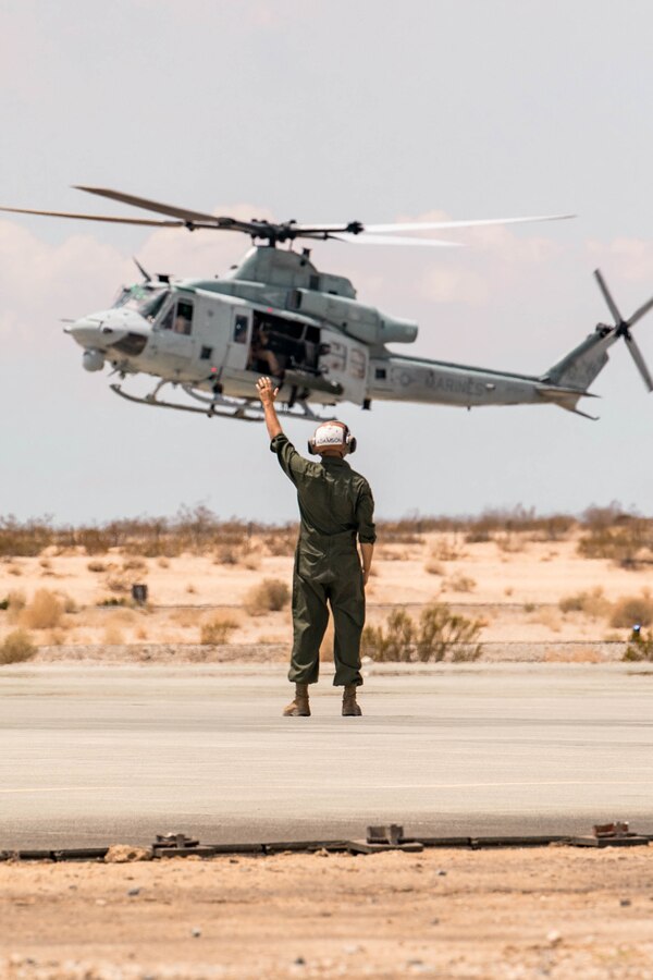 A Marine with Marine Light Attack Helicopter Squadron (HMLA) 773, guides the landing of a UH-1Y Venom during Integrated Training Exercise (ITX) 4-21 at Marine Corps Air Ground Combat Center Twentynine Palms, California on July 28, 2021. HMLA-773 is supporting Marine Air Ground Task Force 25 as part of the Aviation Combat Element during ITX, providing close air support and deep air support to the Ground Combat Element. (U.S Marine Corps photo by Lance Cpl. David Intriago)