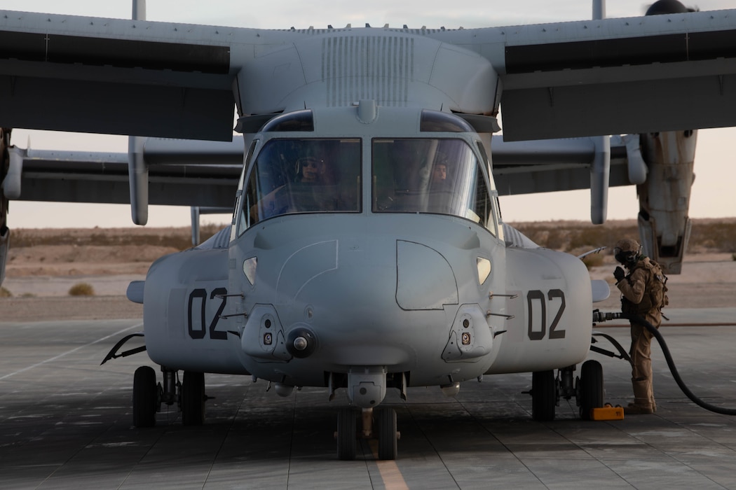A U.S. Marine with Marine Medium Tiltrotor Squadron (VMM) 774 refuels an MV-22 Osprey during Integrated Training Exercise (ITX) 4-21 at Marine Corps Air Ground Combat Center Twentynine Palms, California on July 28, 2021. Marines with Marine Medium Tiltrotor Squadron 774 inserted Lima Company as a part of Battalion Distributed Operations Course, a sub-event of ITX that requires close coordination of air and ground assets in a geographically dispersed area of operations. (U.S Marine Corps photo by Lance Cpl. David Intriago)