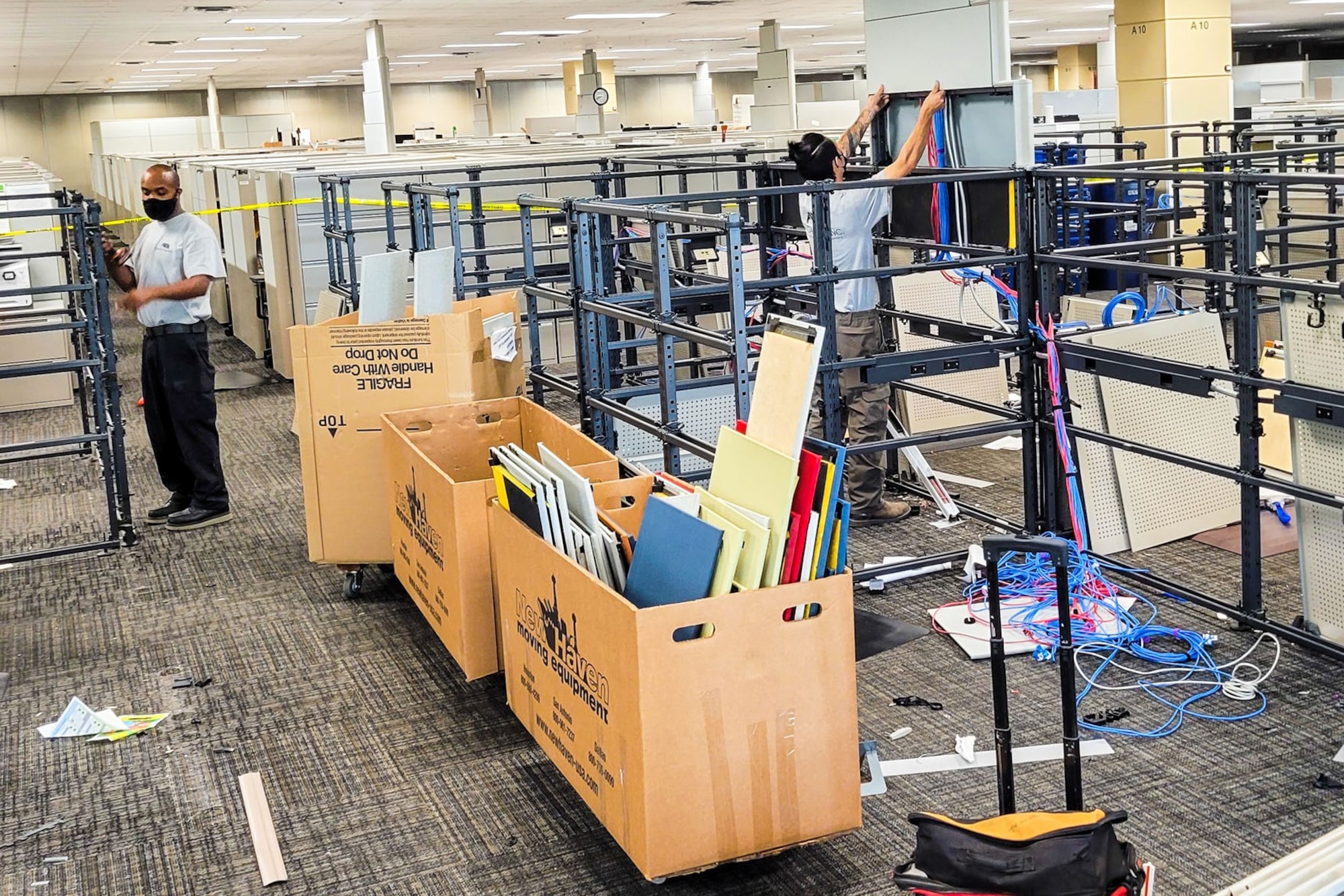 Contractors take apart and remove cubicles in the Air Force Installation and Mission Support Center headquarters building July 29 in San Antonio.