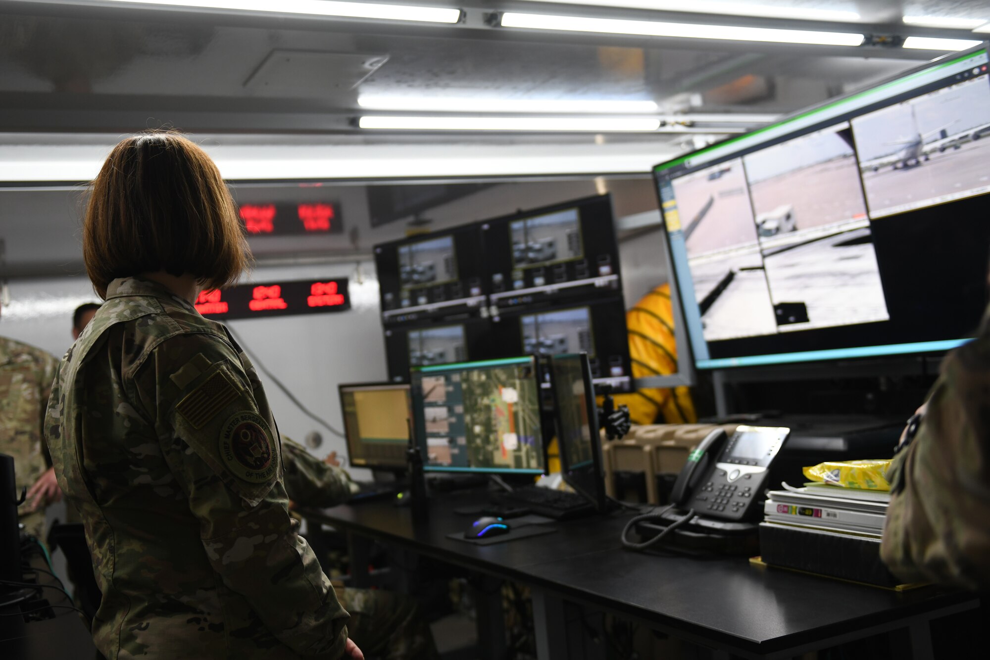Chief Master Sergeant of the Air Force JoAnne S. Bass looks at television monitors in the mobile base defense operations center.