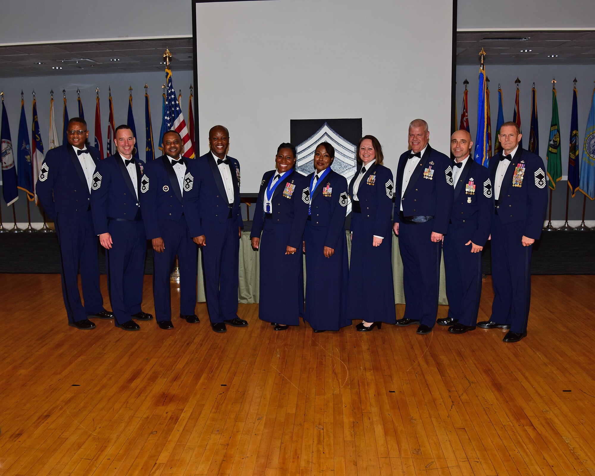 U.S. Air Force Senior Master Sgts. Melissa D. Bridges (center left) and Joi T. Washington (center right), are joined by Chief Master Sgts., retired and active duty for a group photo at the Chief Induction ceremony, July 22, 2021 on Columbus Air Force Base, Miss. The Chief Induction ceremony is a separate recognition event from the monthly promotion ceremony that honors the singularly distinctive accomplishments of those inducted to the rank of Chief. (Multimedia Services photo by Melissa A. Duncan-Doublin)
