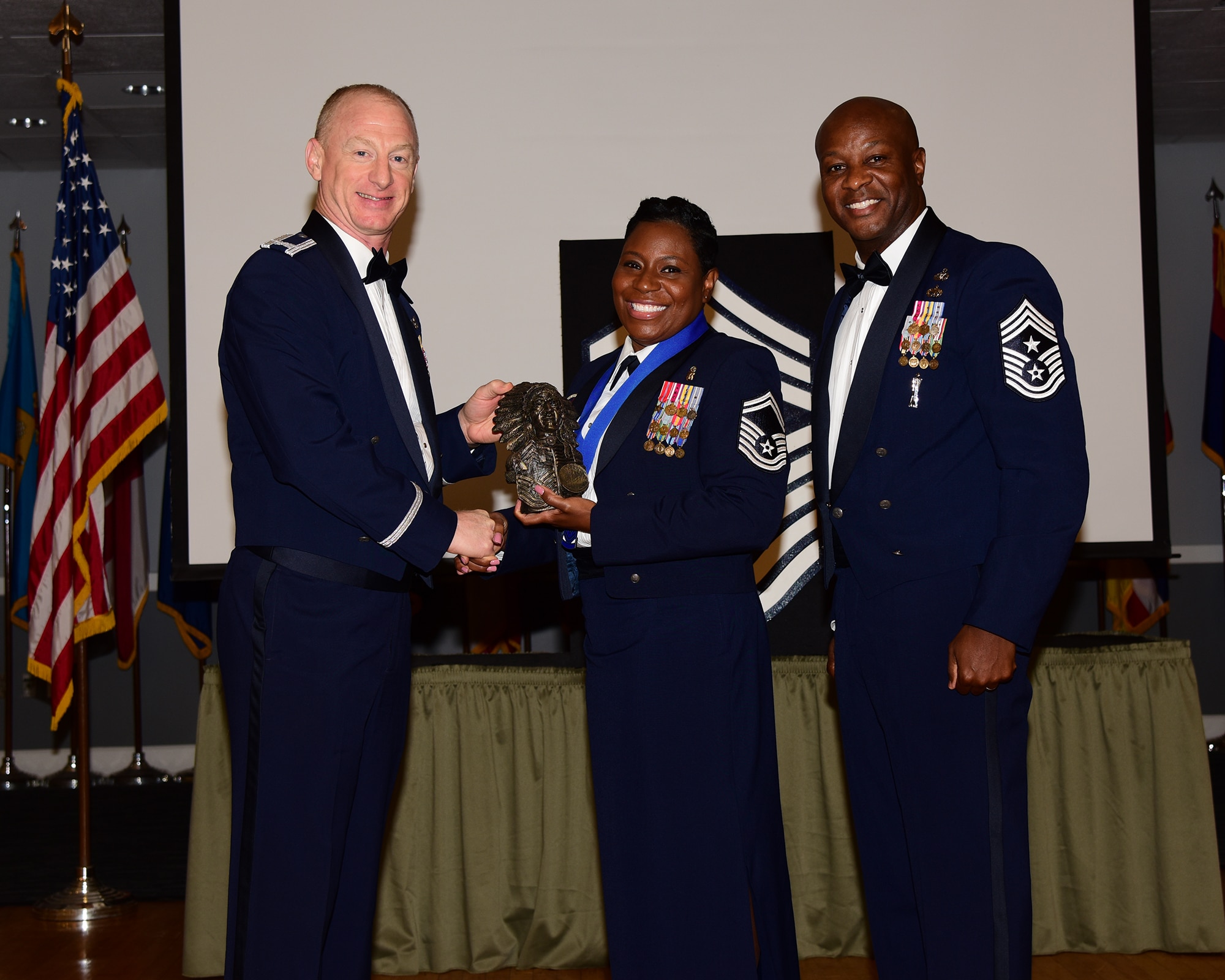 U.S. Air Force Senior Master Sgt. Melissa D. Bridges (center) posed for a photo with Col. Seth W. Graham, 14th Flying Training Wing, commander (left) and Chief Master Sgt. Antonio Cooper, 14th Flying Training Wing, command chief during the Chief Induction ceremony, July 22, 2021 on Columbus Air Force Base, Miss. The Chief Induction ceremony represents the culmination of obtaining the highest enlisted rank, held only by the top one percent of the total enlisted force as authorized by 1958 Career Compensation Act. (Multimedia Services photo by Melissa A. Duncan-Doublin)