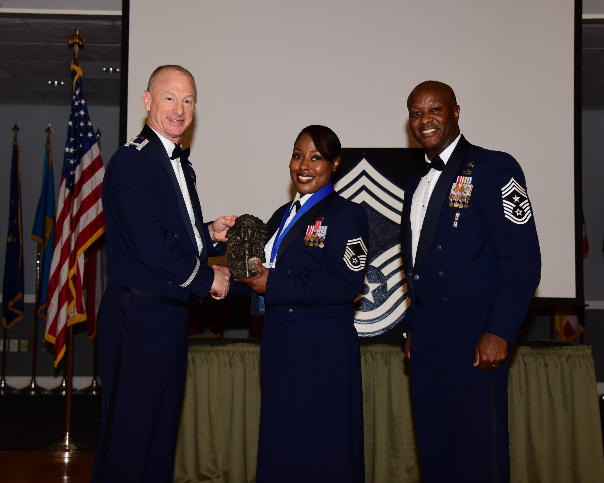 U.S. Air Force Senior Master Sgt. Joi T. Washington (center) posed for a photo with Col. Seth W. Graham, 14th Flying Training Wing, commander (left) and Chief Master Sgt. Antonio Cooper, 14th Flying Training Wing, command chief during the Chief Induction ceremony, July 22, 2021 on Columbus Air Force Base, Miss. Chief Master Sgt. is the ninth and highest enlisted rank in the U.S. Air Force, these non-commissioned officers are expected to serve as mentors for the enlisted force and advisors to commanders and senior officers. (Multimedia Services photo by Melissa A. Duncan-Doublin)