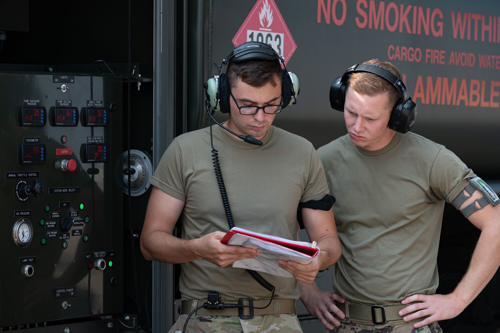 Staff Sgt. Drew Good, left, 436th Logistics Readiness Squadron mobile distribution noncommissioned officer in charge, and Airman 1st Class Griffin Nelson, 436th LRS fuels distribution operator, discuss defuel procedures on Dover Air Force Base, Delaware, July 30, 2021. Airmen from the 436th LRS petroleum, oil and lubricant flight and the 3rd Airlift Squadron performed the first C-17 Globemaster III wet wing defuel procedure at Dover AFB. (U.S. Air Force photo by Senior Airman Marco A. Gomez)