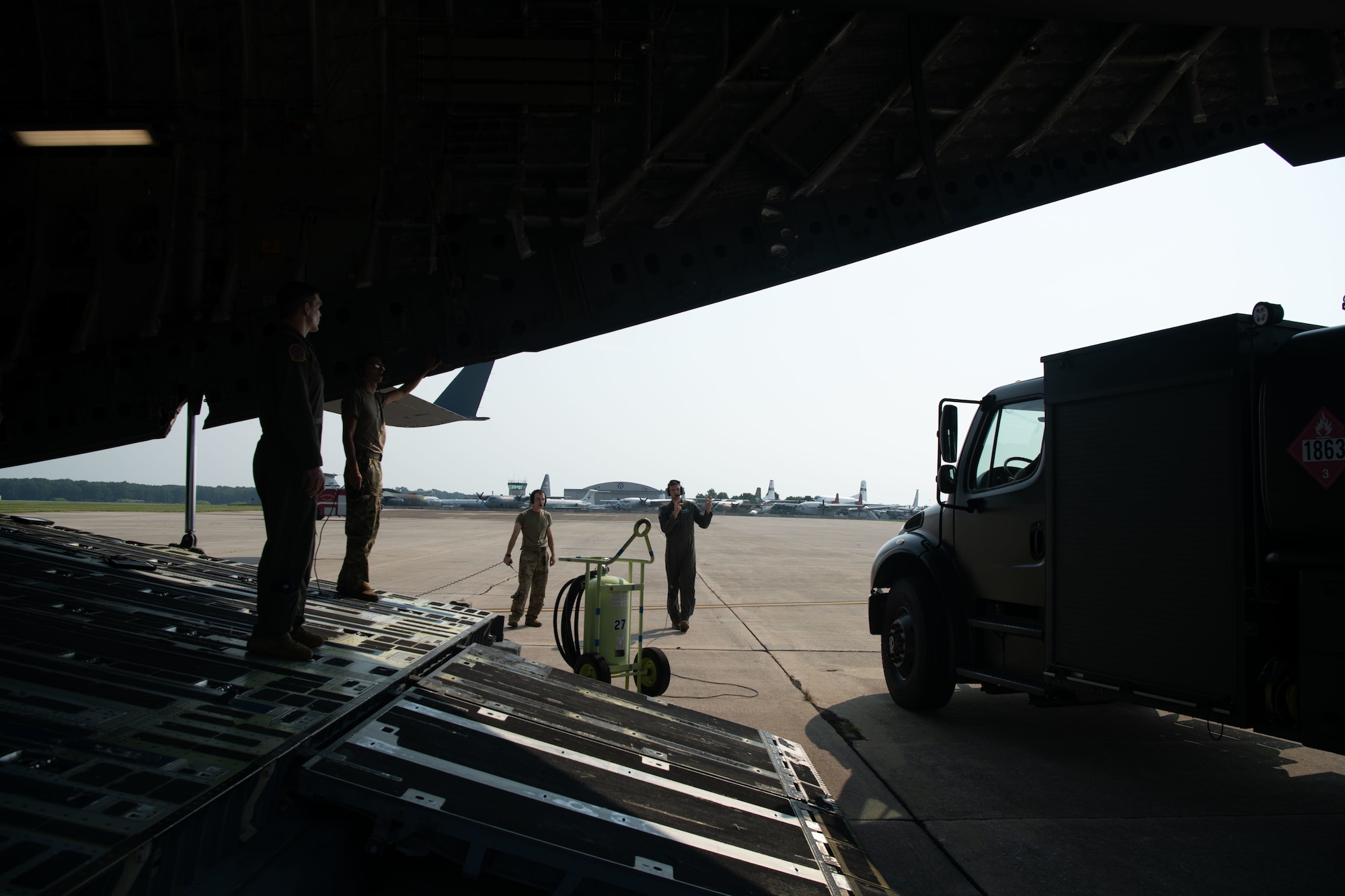 Members of the 3rd Airlift Squadron marshal an R-11 fuel truck behind a C-17 Globemaster III on Dover Air Force Base, Delaware, July 30, 2021. Airmen from the 436th Logistics Readiness Squadron petroleum, oil and lubricant flight and the 3rd AS performed the first C-17 wet wing defuel procedure at Dover AFB. (U.S. Air Force photo by Senior Airman Marco A. Gomez)