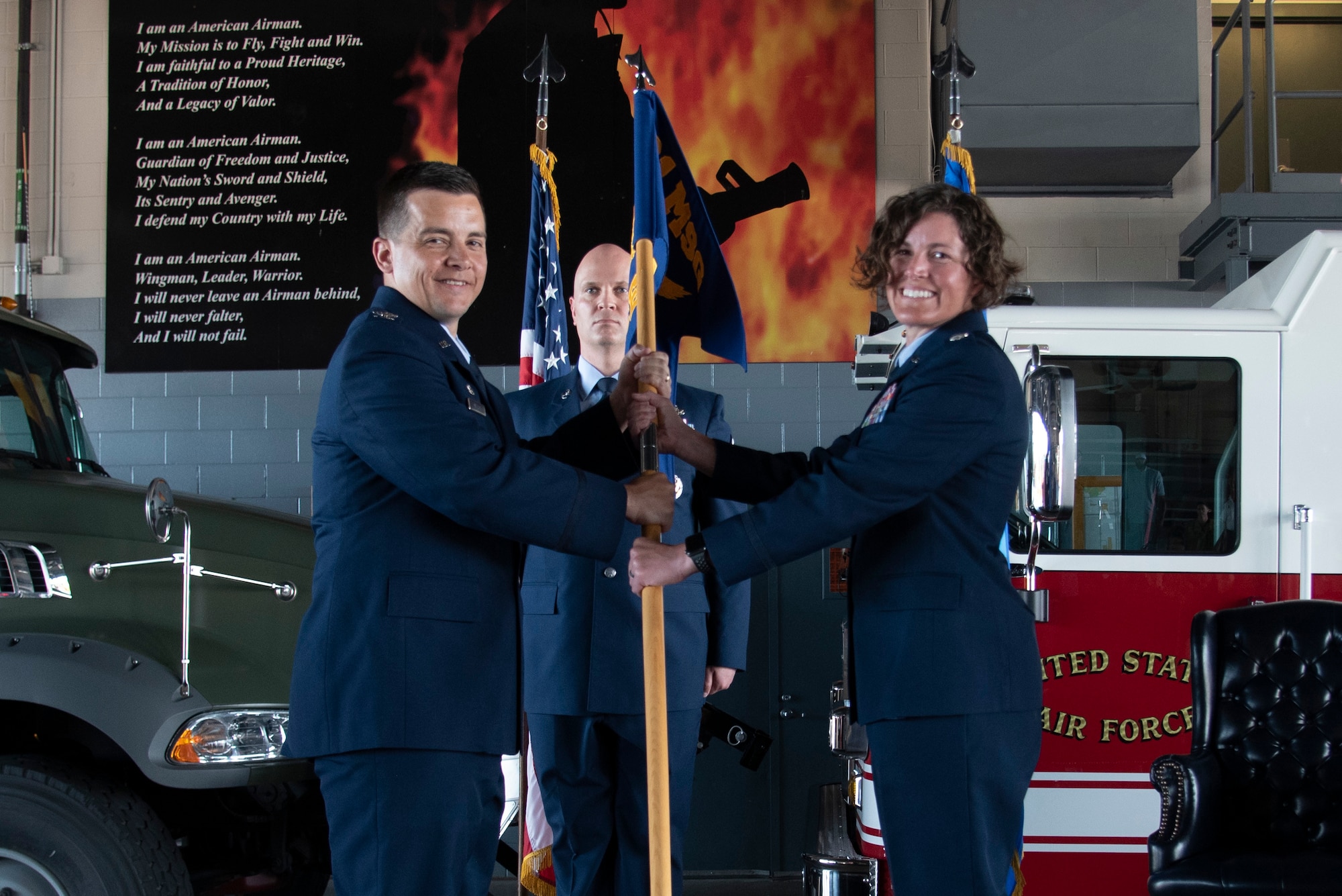 U.S. Air Force Col. David Wilson, 21st Mission Support Group commander, left, passes the 21st Civil Engineer Squadron guidon to U.S. Air Force Lt. Col. Erica Tortella, incoming 21st CES commander, during the change of command ceremony at Peterson Space Force Base, Colorado, July 29, 2021. The 21st CES provides comprehensive technical engineering and environmental support, including contract management and mobile quality assurance to 15 geographically separated units supporting Peterson-Schriever Garrison missions worldwide. (U.S. Space Force photo by Airman Aaron Edwards)