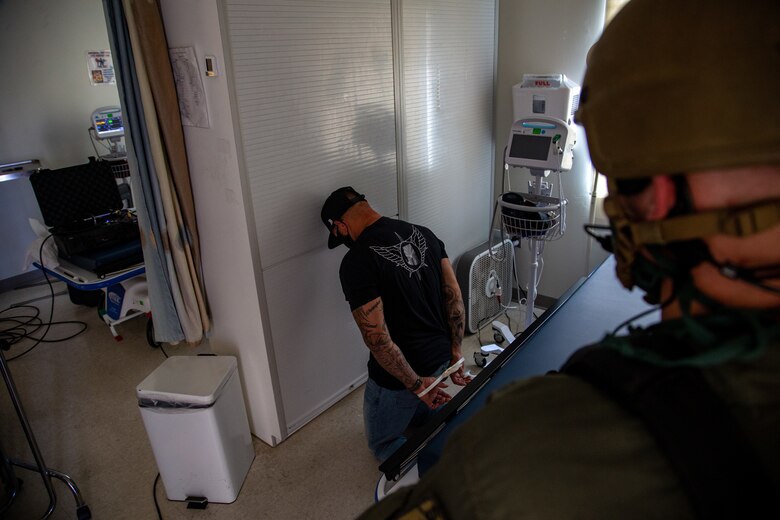 An active-shooter role player is apprehended by military police during Exercise Desert Fire 2021 at the Naval Branch Health Clinic on Marine Corps Air Station Yuma, Ariz., July 28, 2021. Desert Fire is an active-shooter drill implemented to test, evaluate and improve the response and preparedness of first responders on the air station.  (U.S. Marine Corps photo by Lance Cpl. Gabrielle Sanders)