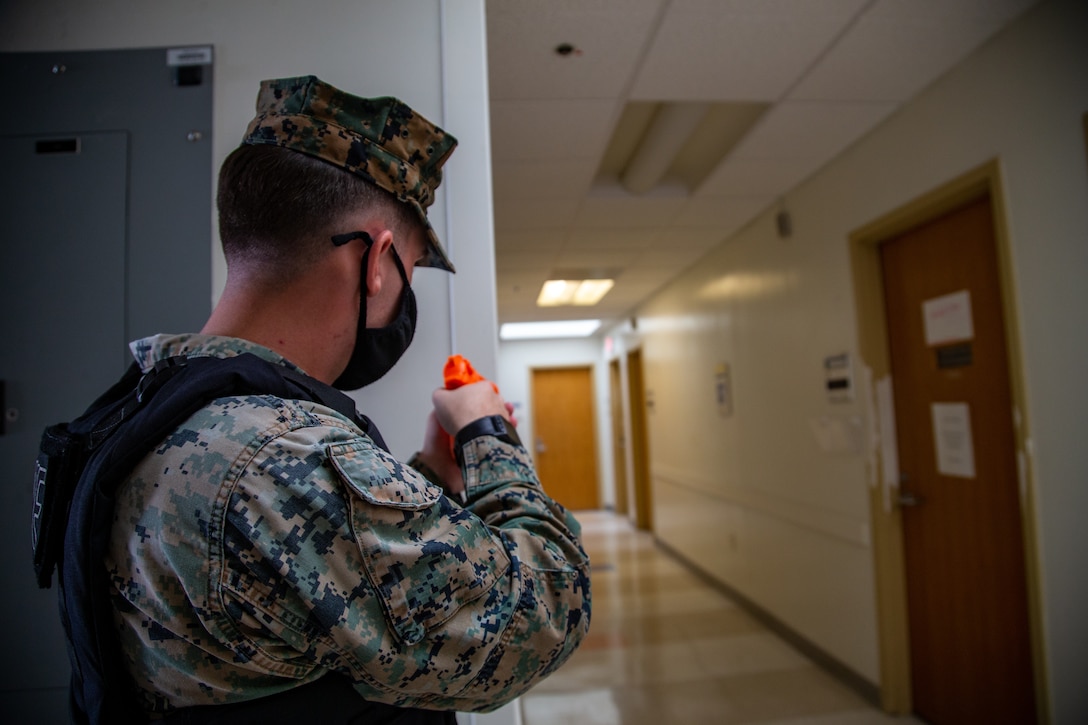 U.S. Marine Corps Cpl. Saige Winfree, a military police officer, points a simulated weapon towards a hostage room during Exercise Desert Fire 2021 at the Naval Branch Health Clinic on Marine Corps Air Station Yuma, Ariz., July 28, 2021. Desert Fire is an active-shooter drill implemented to test, evaluate and improve the response and preparedness of first responders on the air station.  (U.S. Marine Corps photo by Lance Cpl. Gabrielle Sanders)