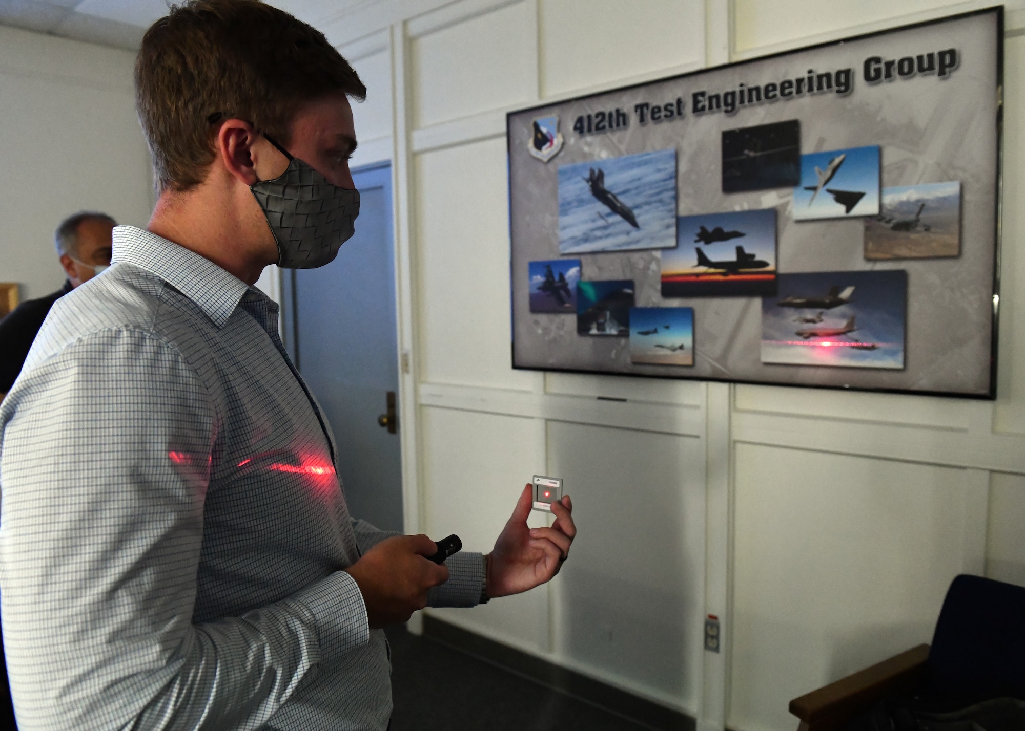 Kevin Meyer, intern engineer, 775th Test Squadron, 412th Test Engineering Group, 412th Test Wing, fires a laser through a filter during a demonstration at Edwards Air Force Base, California, July 26. The EO/IR Flight, 775th Test Squadron, 412th Test Engineering Group, 412th Test Wing, developed an improved training program that was supported by SparkEd, the official AFWERX-recognized Spark Cell for Edwards AFB.