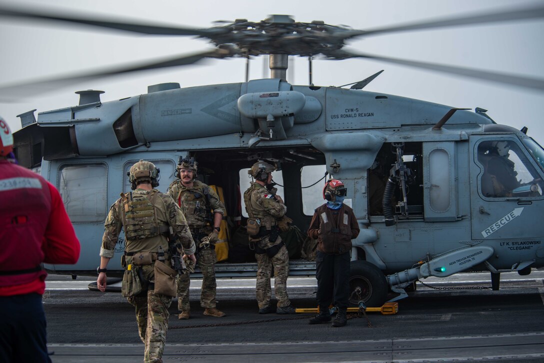 210730-N-WS494-1238 ARABIAN SEA (July 30, 2021) – Sailors assigned to Explosive Ordnance Disposal Mobile Unit (EODMU) 5 board an MH-60S Sea Hawk helicopter, attached to the “Golden Falcons” of Helicopter Sea Combat Squadron (HSC) 12, on the flight deck of aircraft carrier USS Ronald Reagan (CVN 76) in response to a call for assistance from a vessel in distress in the Arabian Sea, July 30. Ronald Reagan is deployed to the U.S. 5th Fleet area of operations in support of naval operations to ensure maritime stability and security in the Central Region, connecting the Mediterranean and Pacific through the western Indian Ocean and three strategic choke points. (U.S. Navy photo by Mass Communication Specialist 2nd Class Quinton A. Lee)