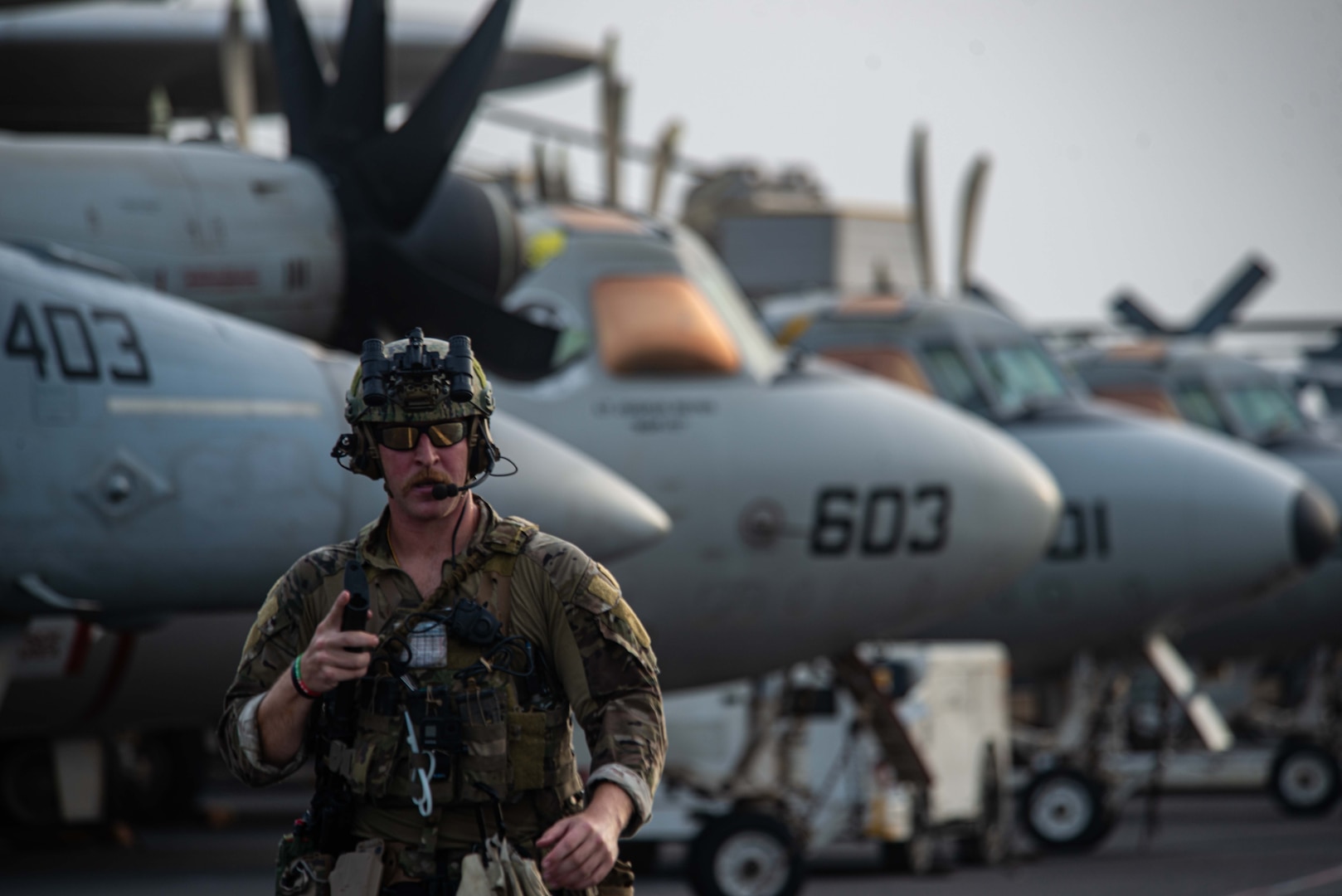 210730-N-WS494-1258 ARABIAN SEA (July 30, 2021) –Explosive Ordnance Disposal Technician 3rd Class Ethan Tews, assigned to Explosive Ordnance Disposal Mobile Unit (EODMU) 5, walks across the flight deck of aircraft carrier USS Ronald Reagan (CVN 76) in response to a call for assistance from a vessel in distress in the Arabian Sea, July 30. Ronald Reagan is deployed to the U.S. 5th Fleet area of operations in support of naval operations to ensure maritime stability and security in the Central Region, connecting the Mediterranean and Pacific through the western Indian Ocean and three strategic choke points. (U.S. Navy photo by Mass Communication Specialist 2nd Class Quinton A. Lee)