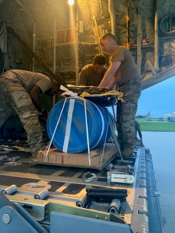 A team of U.S. Air Force Airmen load an airdrop bundle of medical supplies onto a U.S. Air Force C-130J Super Hercules, call sign 