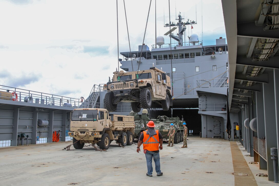 Soldiers load supplies onto a ship.