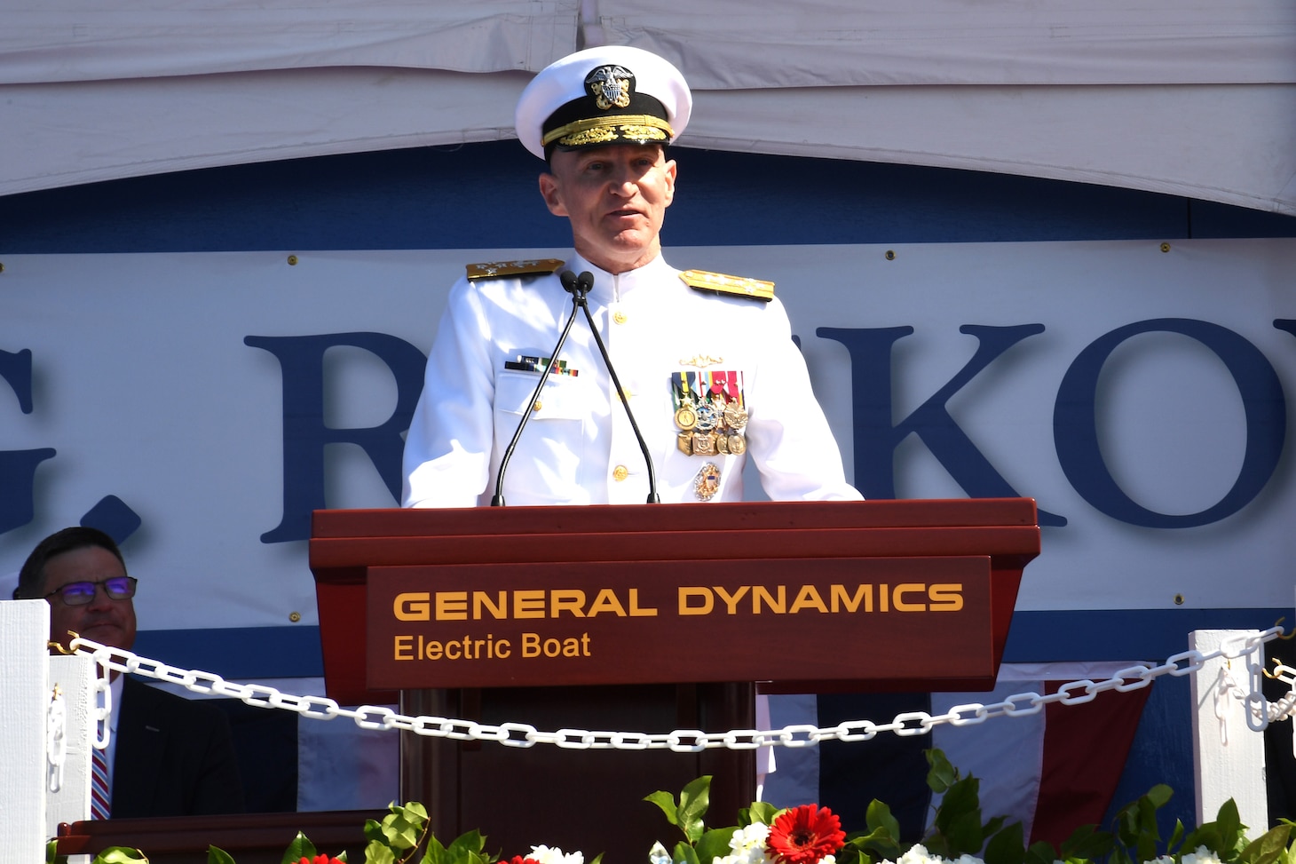 Adm. James Caldwell, Jr., director of the Naval Nuclear Propulsion Program, delivers remarks in front of the pre-commissioning unit (PCU) Hyman G. Rickover (SSN 795) during a christening ceremony at General Dynamics Electric Boat shipyard facility in Groton, Conn., July 31, 2021.