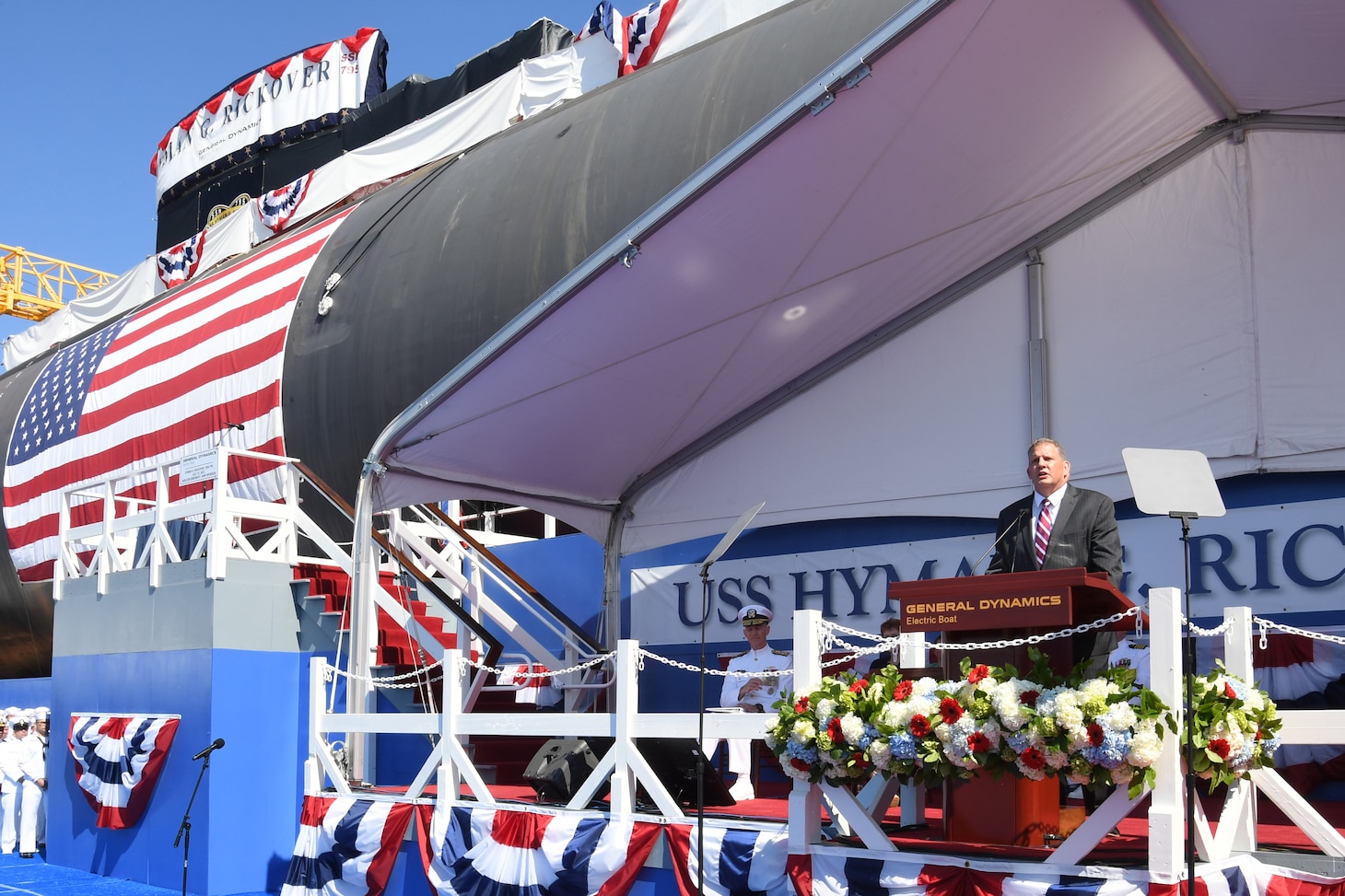 Under Secretary of the Navy James Geurts delivers remarks in front of the pre-commissioning unit (PCU) Hyman G. Rickover (SSN 795) during a christening ceremony at General Dynamics Electric Boat shipyard facility in Groton, Conn., July 31, 2021.