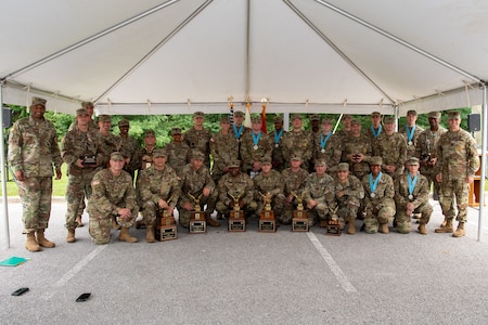 large group of soldiers in army uniform standing in front of flags.